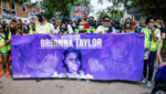 protesters hold sign