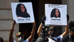 protesters hold signs