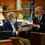 Robert Durst speaks with his attorney in court