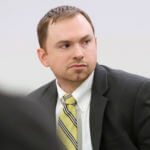 A man in a suit sits in court