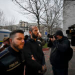 Police officers escort Andrew Tate
