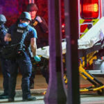 A stretcher is unloaded from an ambulance outside the Michigan State University Union following shootings
