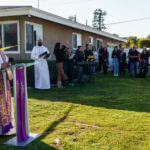 The Rev. Albert Avenido, left, and sacristan Hector Ibarra lead members of Sacred Heart Catholic Church in Covina, Calif., on a prayer vigil for Bishop David O'Connell