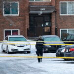 Police investigate the scene where two officers were shot and killed