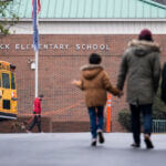 students and parents walking away from the camera into Richneck Elementary School
