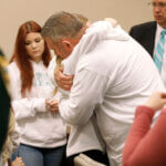 Forrest Bailey, the father of victim Tristyn Bailey, gets a hug from a family member
