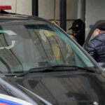 Wall Street Journal reporter Evan Gershkovich is escorted by officers