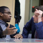 Michael Boatwright speaks to his attorney while sitting in court