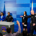 San Francisco Police Chief William Scott, second from left, answers questions from reporters