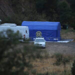 A police tent and vehicles are seen near the Arade dam