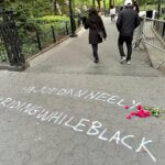 People walk past graffiti calling attention to death of Jordan Neely