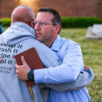 Pastor Ryan Wells hugs Nathan Brewer