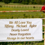 Sign saying "We all love you Tiffany Michael Rylee Dearly Loved Never Forgotten Always in our Hearts"