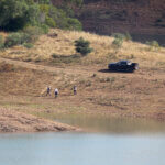 police search team walk on the shore of the Arade dam near Silves,