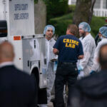 officers stand guard as law enforcement searches the home of Rex Heuermann,