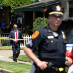 officers stand guard as law enforcement searches the home of Rex Heuermann,