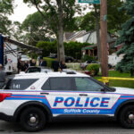 Police officers stand guard near the house where a suspect has been taken into custody on New York's Long Island