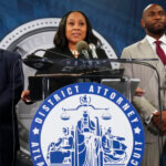 Fulton County District Attorney Fani Willis, center, speaks in the Fulton County Government Center