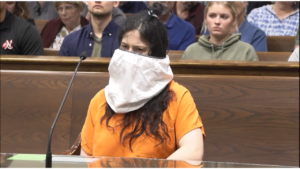 What is a spit hood, and why was Taylor Schabusiness wearing it?