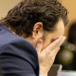 Charlie Adelson puts his head in his hands
