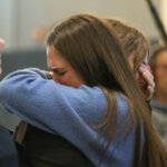 Caitlin Cash hugs a woman outside of court