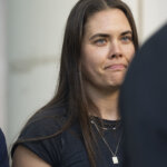 Caitlin Cash stands at a press conference