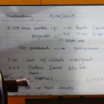 Man speaks in front of whiteboard