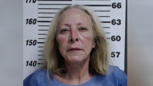 Mother charged with murder after adult son’s body found behind wall