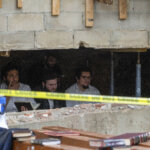 Hasidic Jewish students observe as law enforcement establishes a perimeter