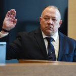 a man is sworn in on the witness stand