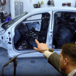 A man points to a car in a photo
