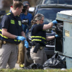 Police search a trash bin