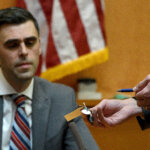 Knowles shows Manchester Police Officer Craig Stanzel a USB storage device