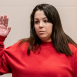 Kayla Montgomery stands with her arm raised as she is sworn in