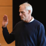 A man raises his hand to be sworn in court