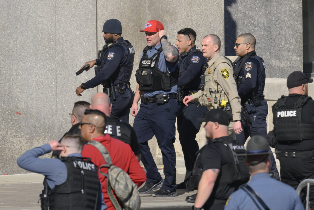 police walk together in vests with guns drawn