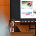A woman sits on the witness stand