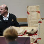 Court officer stands with evidence