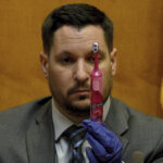 A man holds up a pink child's toothbrush