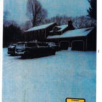 Cars parked in the snowy driveway at night