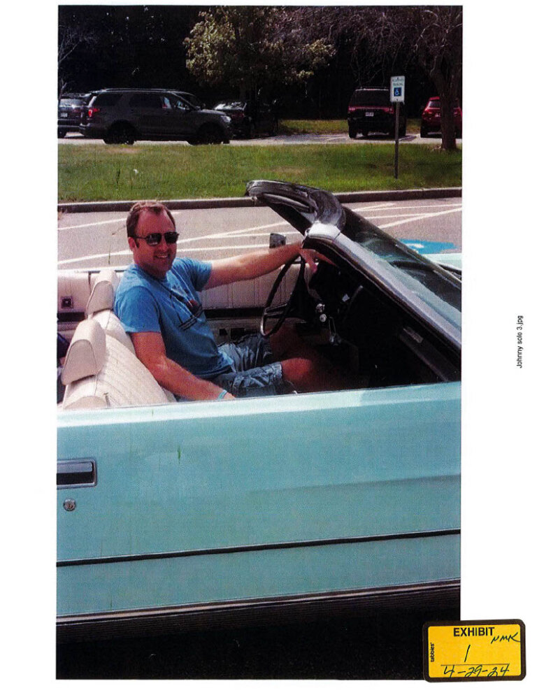 Photo of John O'Keefe driving a 1970s Ford LTD