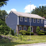 An empty flagpole is seen outside the residence