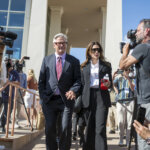 man and woman leave building holding hands