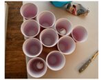 cups set up in a pyramid on a table with ping pong balls and knife