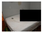 Blood on the wall, bed with black redaction square.