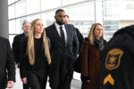 Sherrone Moore, second from right, walks with his wife