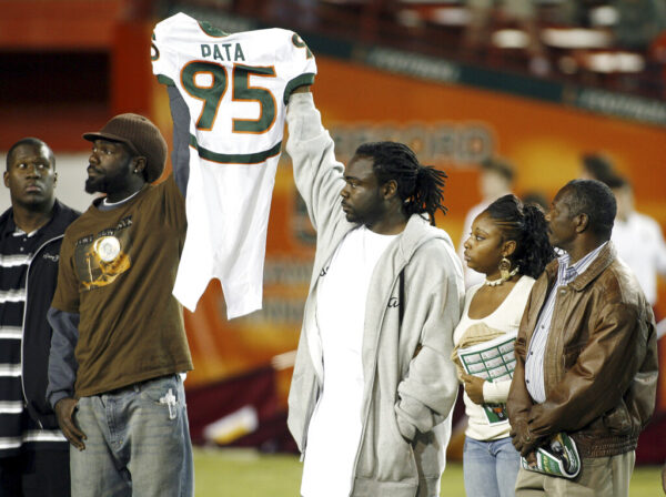 People hold up football uniform