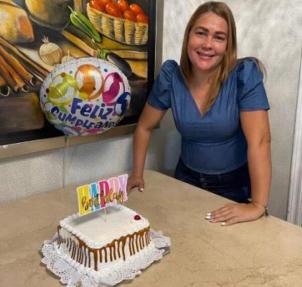 Runyleidy Medina-Pacheco stands with a birthday cake and balloon