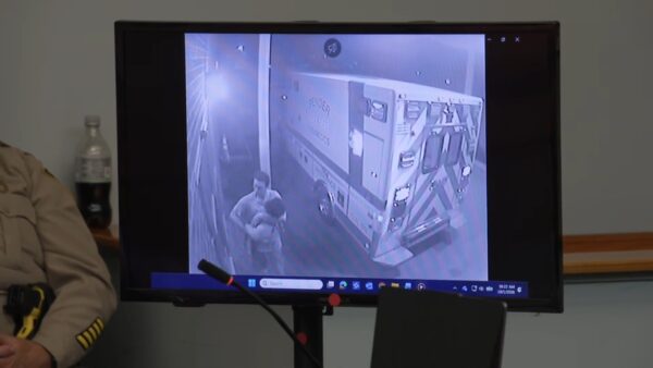 Surveillance video showing man carrying a girl is played on a courtroom monitor