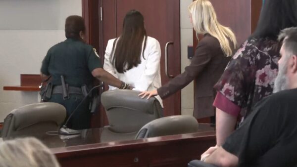 Leigha Mumby is led out of the courtroom in handcuffs